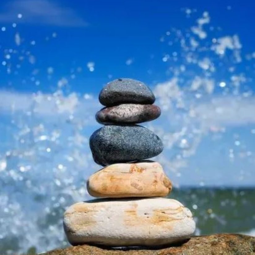 Stacked stones on shore with waves splashing